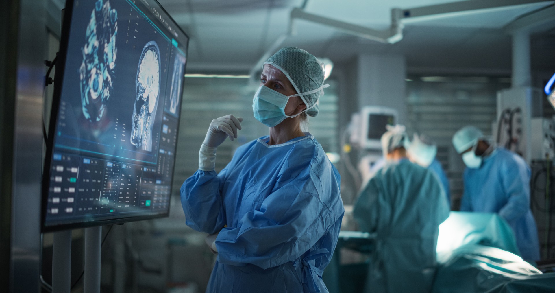 Professional Focused Caucasian Female Surgeon Reviewing Patient's Brain Scans on a Large Monitor, Preparing to Lead Her Team in a Complex Surgery, Analyzing Data Before the Procedure Begins